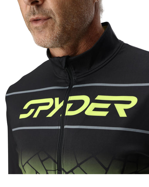 Person wearing a black and green Spyder jacket on a white background
