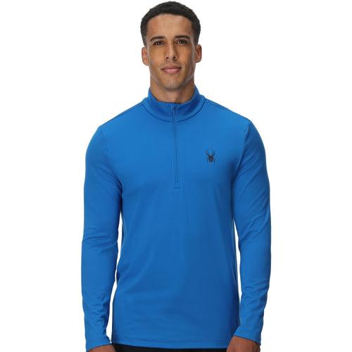 Man wearing a blue long-sleeve shirt with a brand logo on a white background