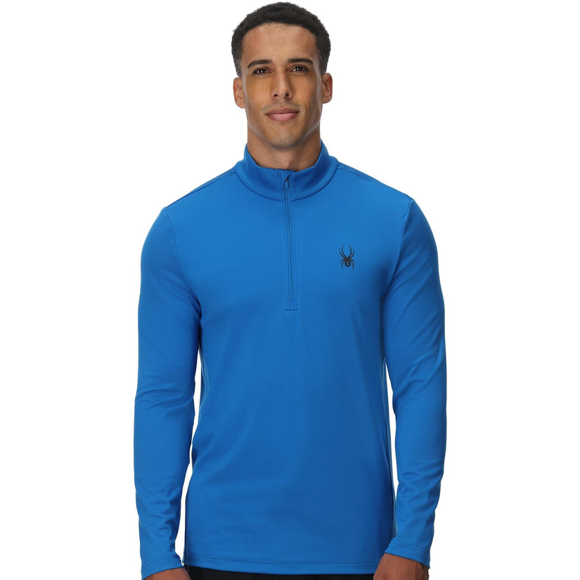 Man wearing a blue long-sleeve shirt with a brand logo on a white background