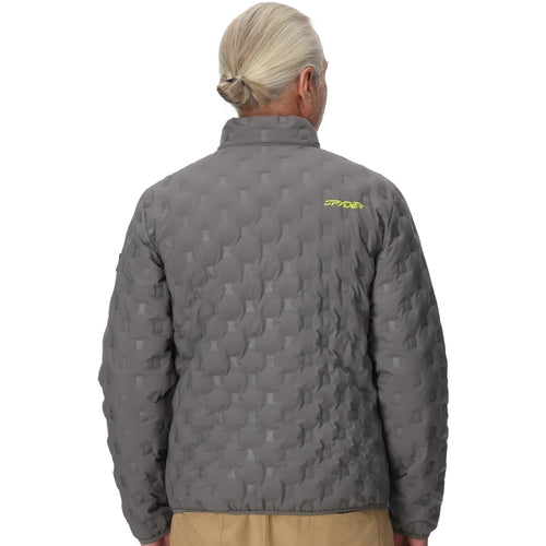 Man wearing a gray quilted jacket with yellow zippers on a white background
