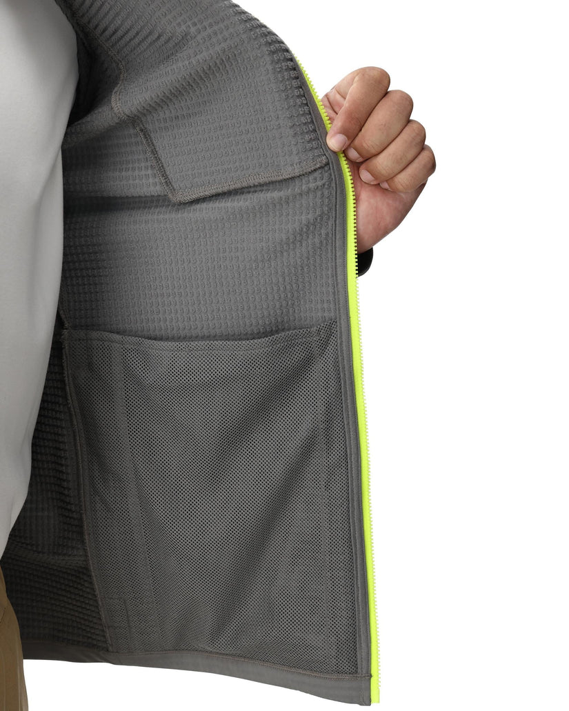 Gray jacket with a yellow zipper held open by a hand on a white background