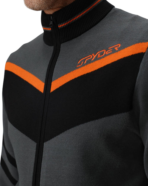 Man wearing a gray jacket with orange and black accents on a white background