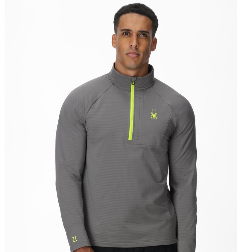 Man wearing a gray quarter-zip pullover with a logo on a white background