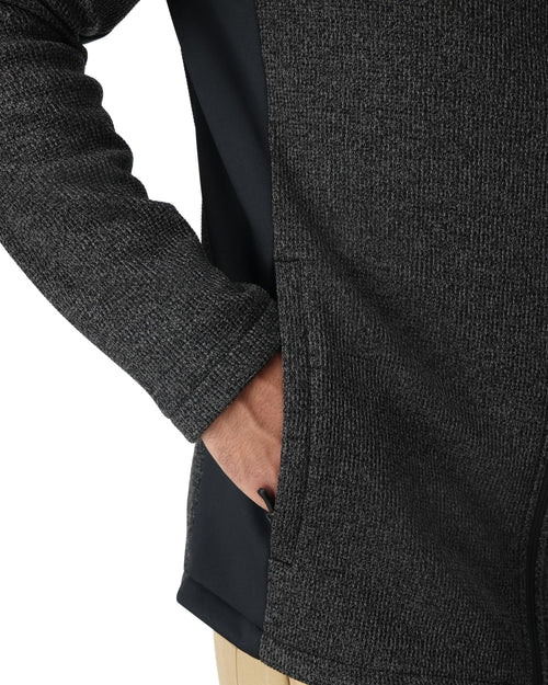 Man wearing a dark gray fleece jacket with a brand logo on a white background