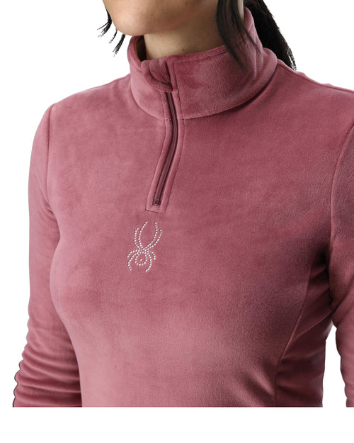 Woman wearing a pink long-sleeve shirt with a brand logo on a white background