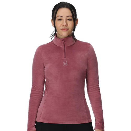 Woman wearing a pink long-sleeve shirt with a brand logo on a white background