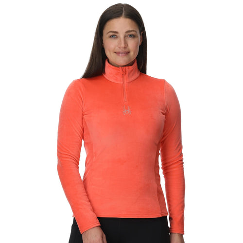 Woman wearing an orange long-sleeve athletic top on a white background