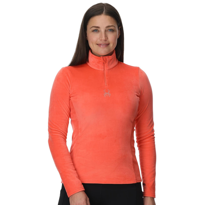 Woman wearing an orange long-sleeve athletic top on a white background
