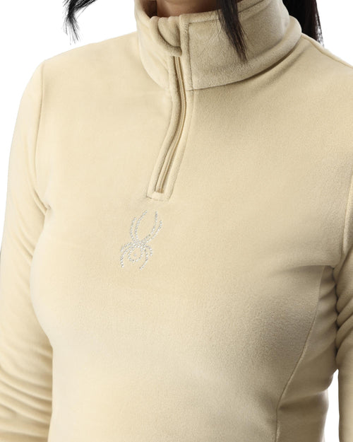 Woman wearing a beige long-sleeve shirt with a zipper on a white background