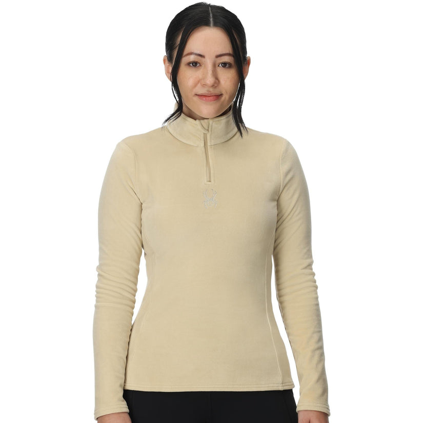 Woman wearing a beige long-sleeve shirt with a zipper on a white background
