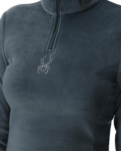 Woman wearing a gray long-sleeve shirt with a brand logo on a white background