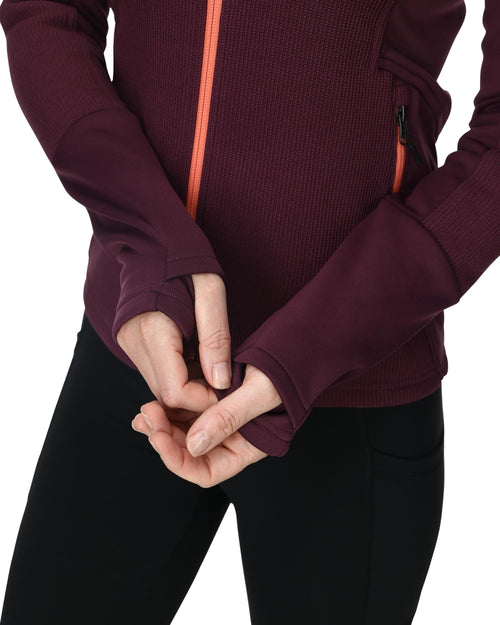 Woman wearing a maroon jacket with a red zipper on a white background