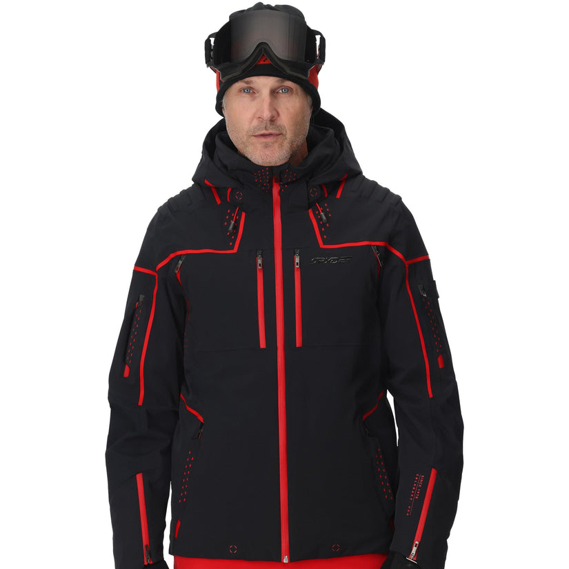 Person wearing a black and red ski jacket with goggles on a white background