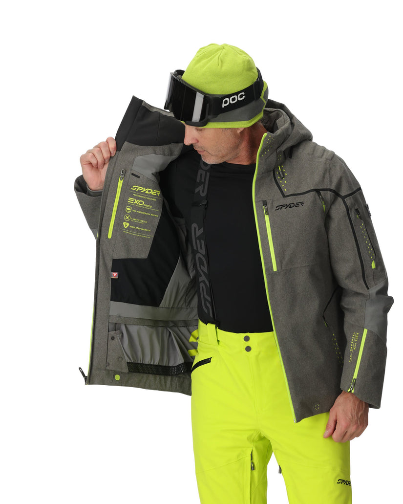 Person wearing a gray and green jacket with a white background