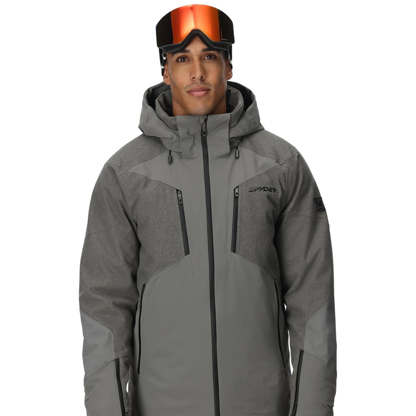 Person wearing a gray ski jacket with goggles on a white background