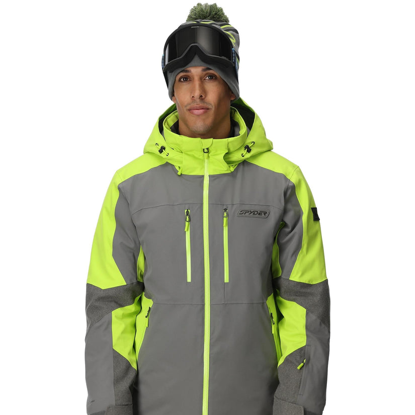 Person wearing a gray and green ski jacket with goggles on a white background