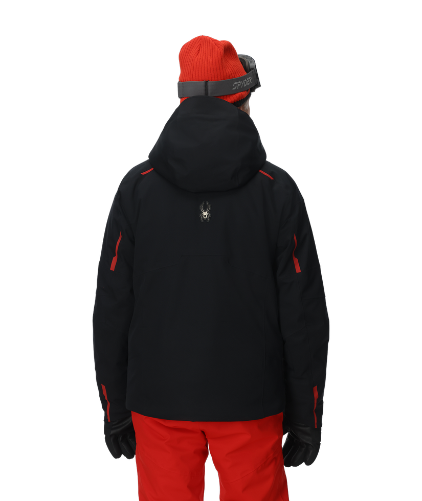 Person wearing a black jacket with red accents and red pants on a white background