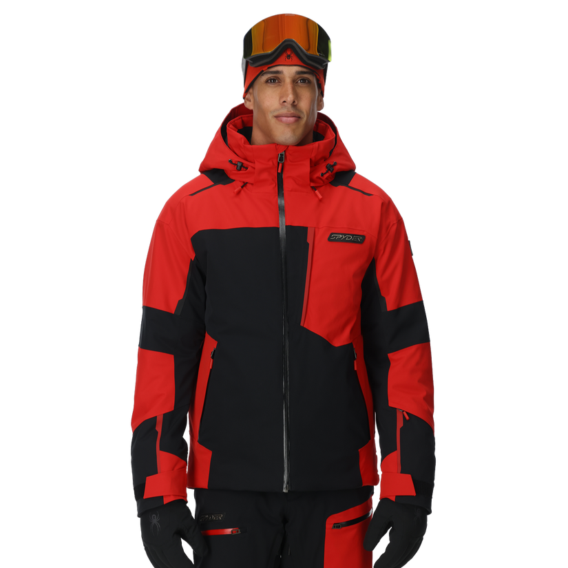 Person wearing a red and black ski jacket with goggles on a white background