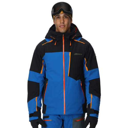 Person wearing a blue and black ski jacket with orange accents on a white background