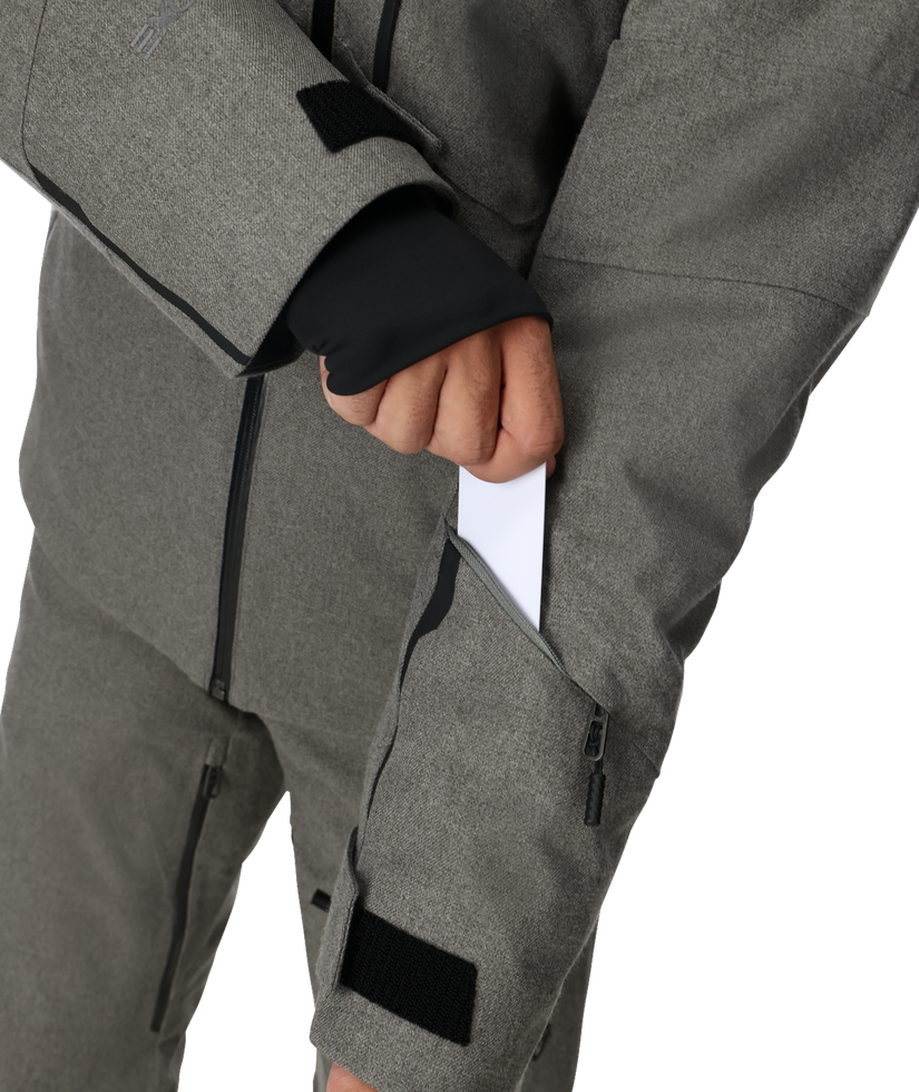 Gray snow pants with black zippers and patches on a white background