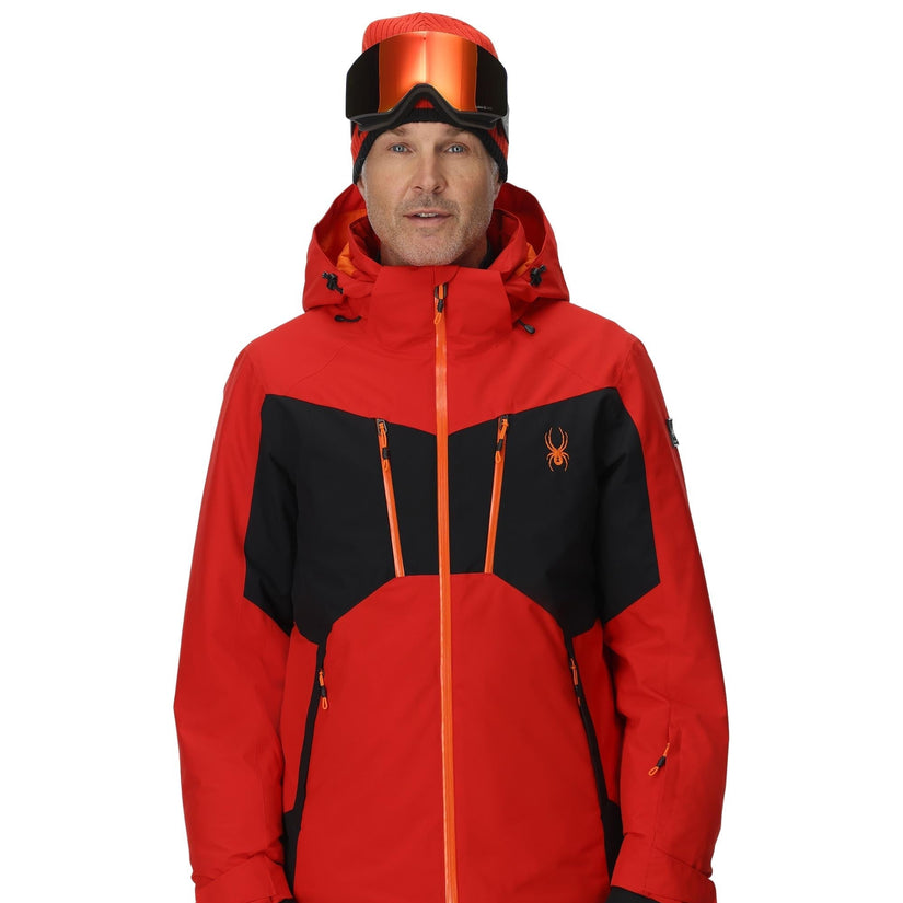 Person wearing a red and black ski jacket with a brand logo on a white background