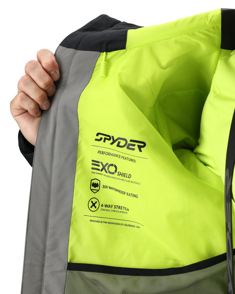 Close-up of a green jacket with Spyder branding and feature text.