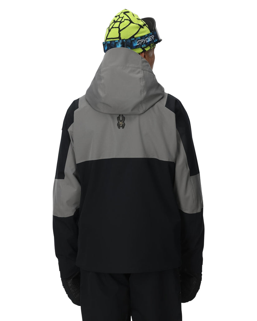 Person wearing a black and gray jacket with a hood on a white background