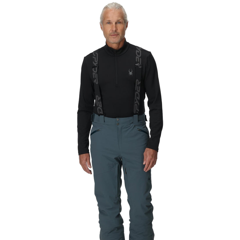 Man wearing a black long-sleeve shirt and blue pants with a white background
