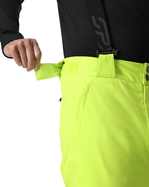 Person wearing a black top and bright green pants on a white background