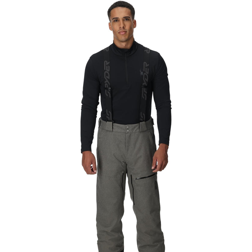 Man wearing a black jacket and gray pants on a white background