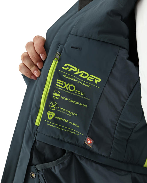 Person wearing a gray ski jacket with green accents on a white background