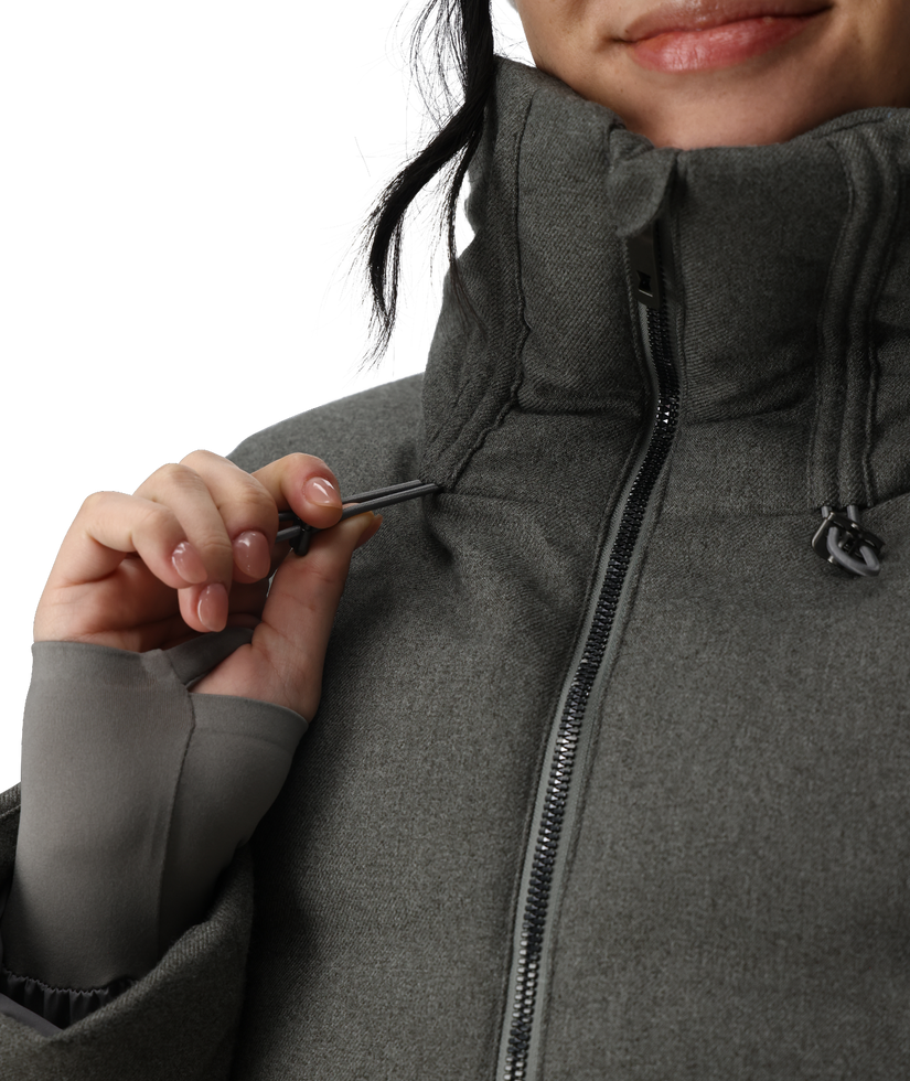 Person wearing a gray jacket with a close-up of the zipper.